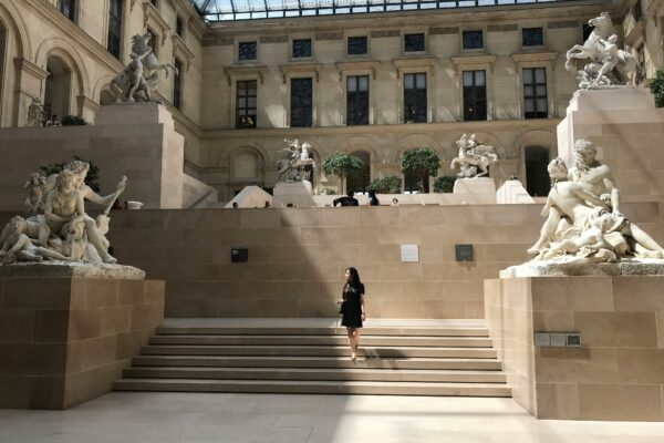 woman standing on stairs in front of museum