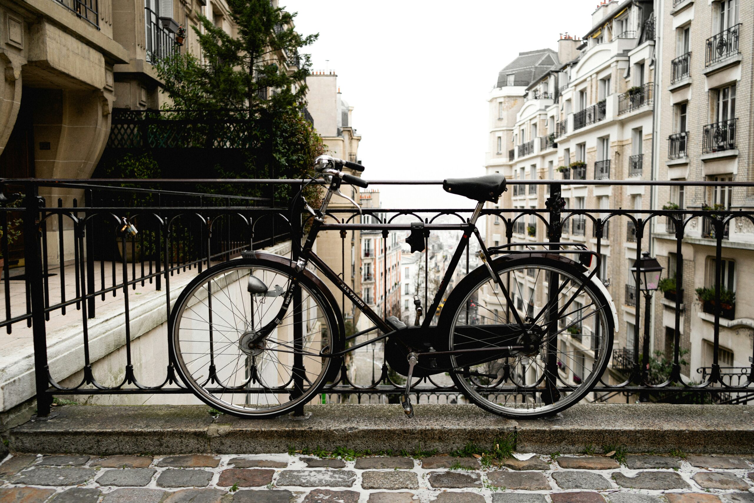black city bike parked beside black metal fence during daytime