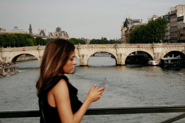 woman in black tank top standing near body of water during daytime