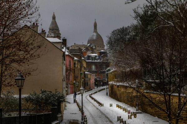 Snow-covered street with buildings and bare trees