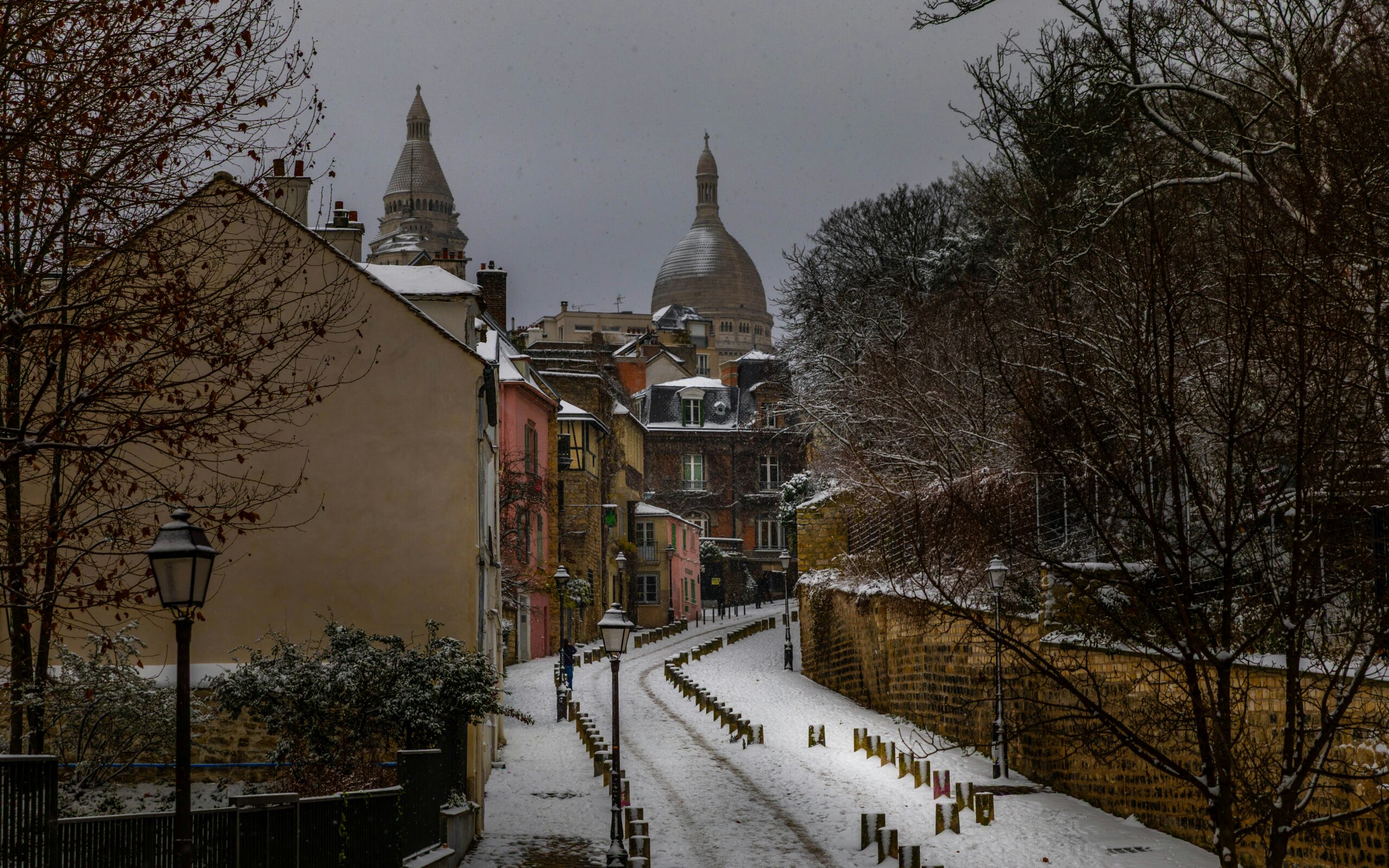 Snow-covered street with buildings and bare trees
