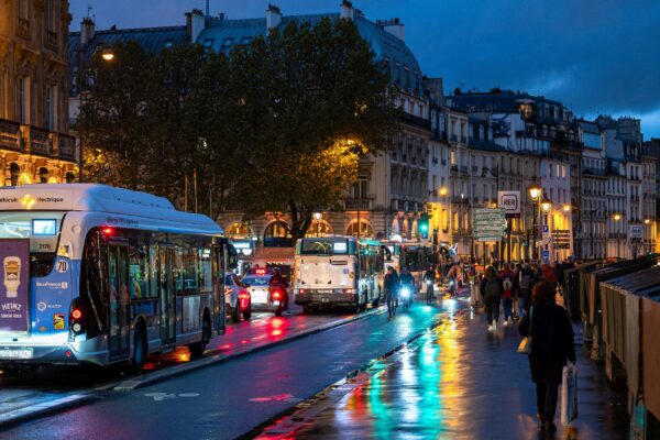 a city street filled with lots of traffic next to tall buildings