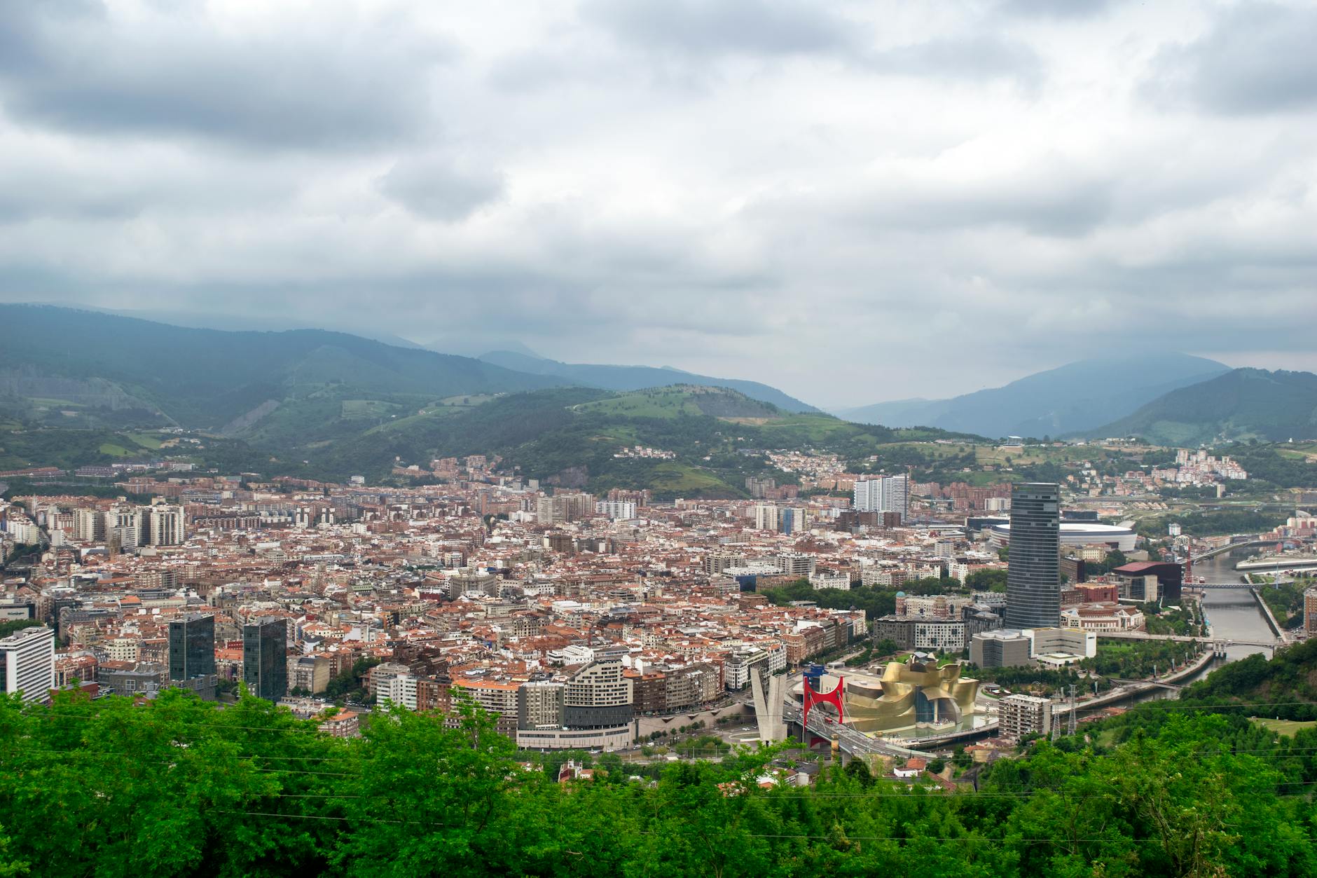 Aerial view of Bilbao, Spain featuring the Guggenheim Museum and surrounding urban landscape.