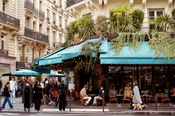 People dining at outdoor cafe with lush greenery