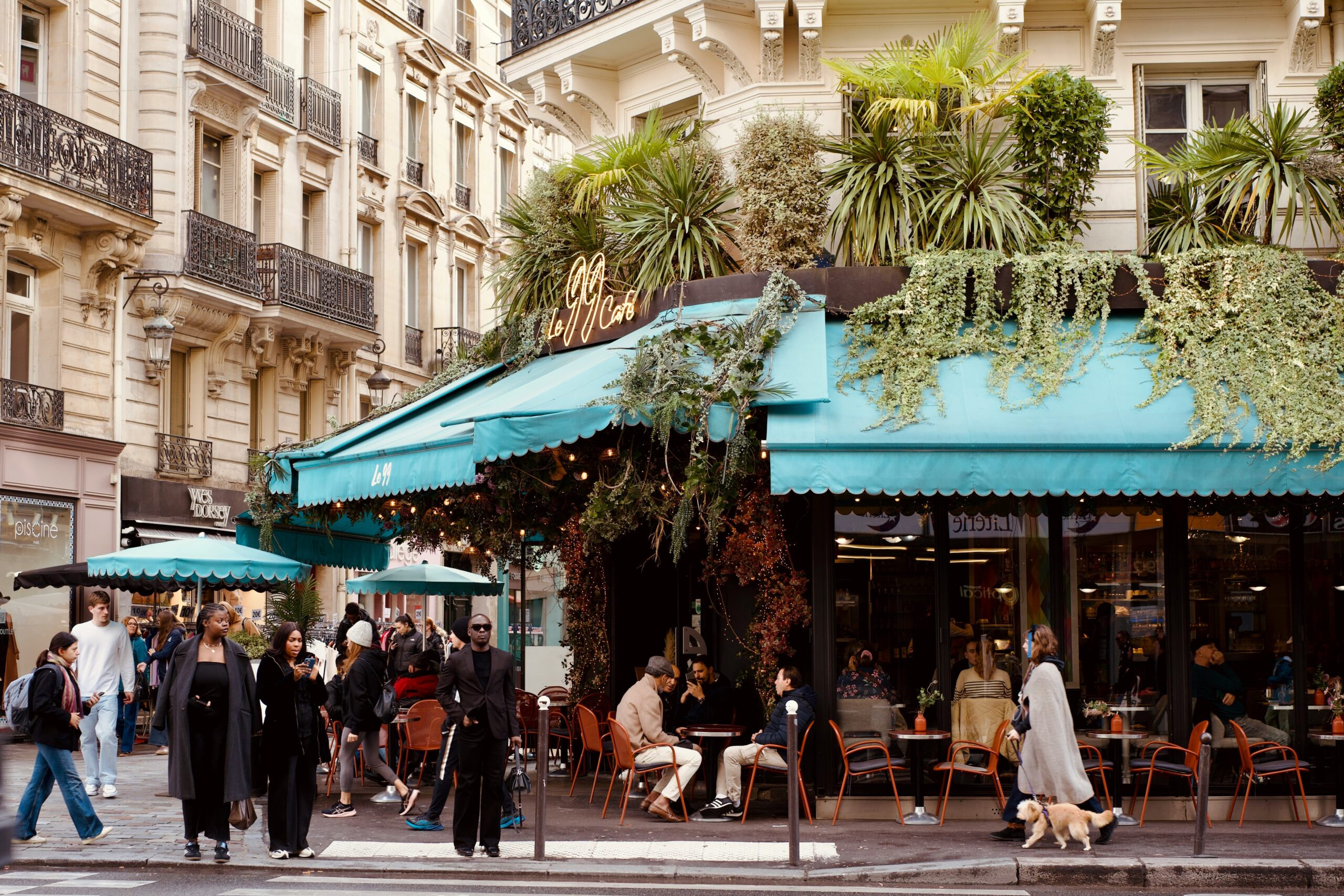People dining at outdoor cafe with lush greenery